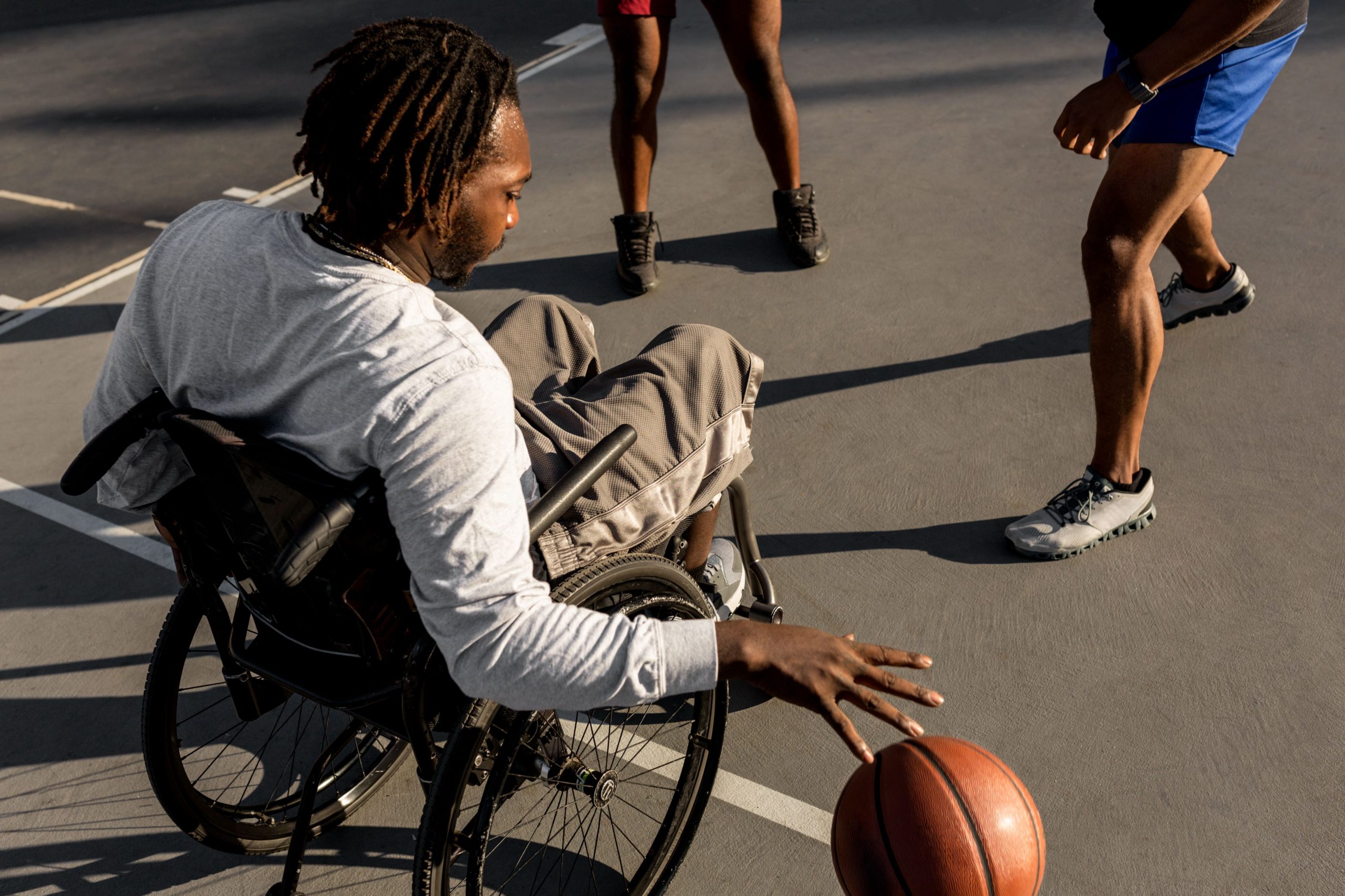 disabled-man-wheelchair-playing-basketball-with-his-friends-outdoors